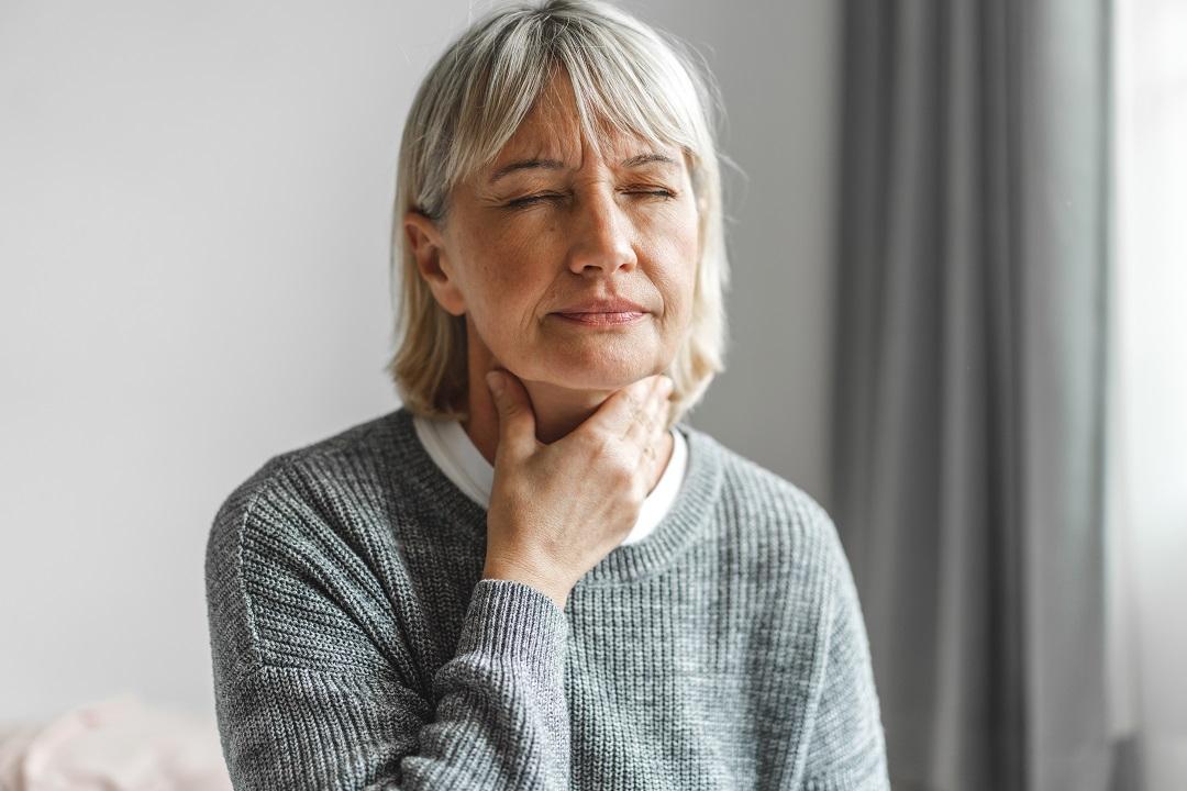 Senior woman with flu symptom sore throat