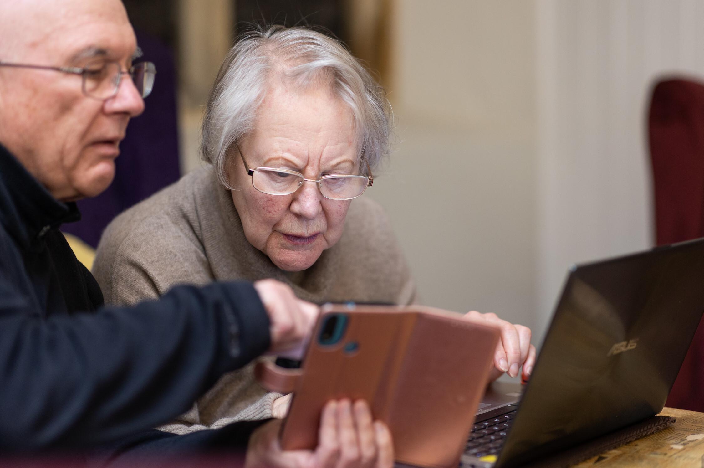 woman and man with vision loss looking at a smart phone